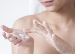 woman-touching-white-lotion-on-the-palm-of-her-hand
